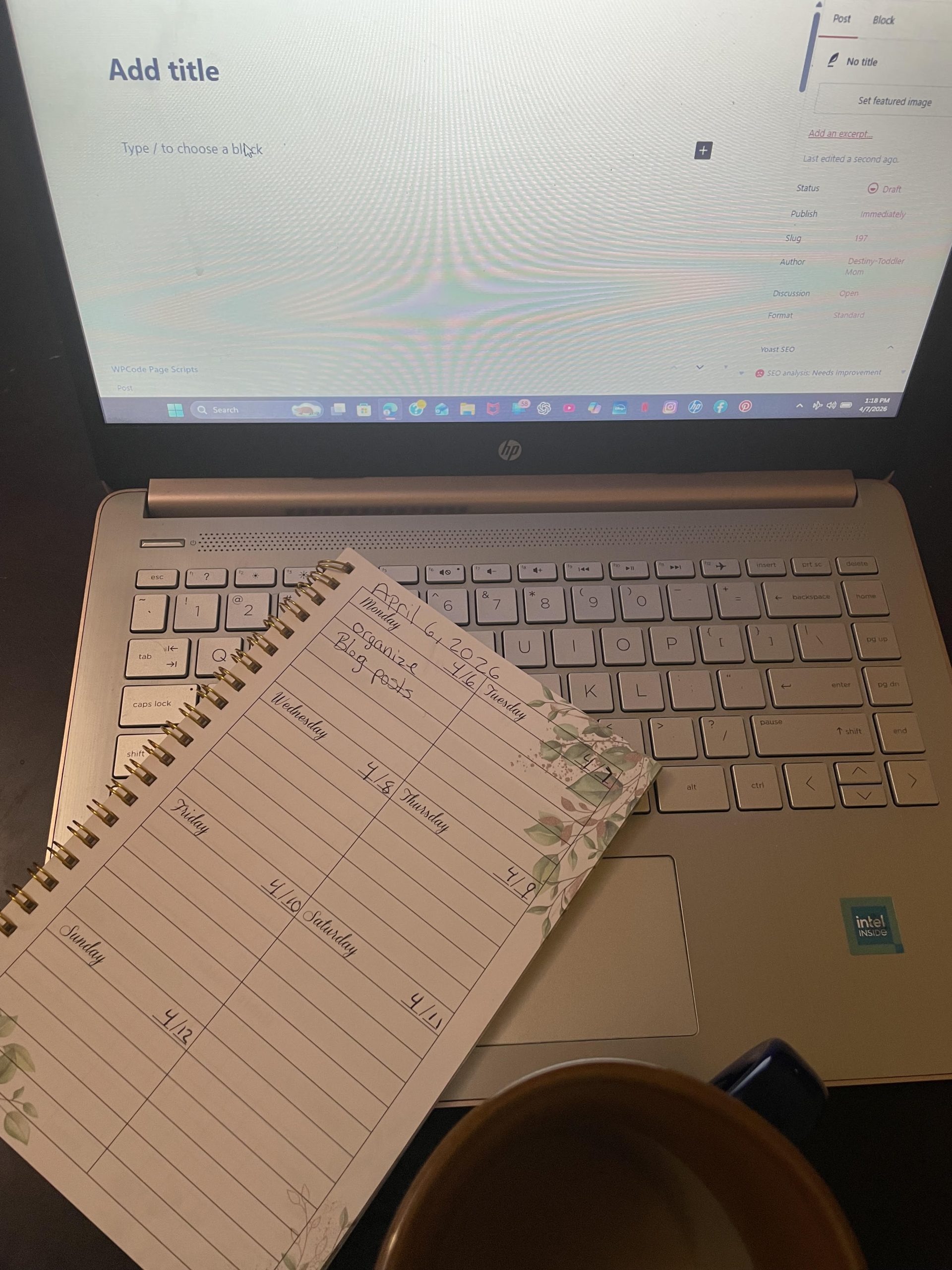 Being a mom: blogging setup with a laptop, weekly organizer, and coffee, reflecting the highs and lows of everyday motherhood.